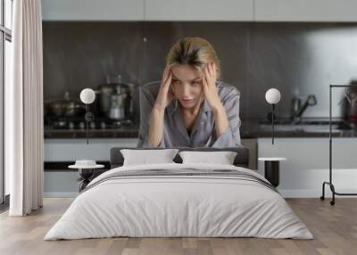 Sad young woman with a cup of coffee in kitchen. Upset girl drinking coffee. Morning of unhappy woman with bad news. Wall mural