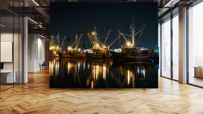 Nighttime scene of a commercial fishing operation with illuminated boats, fishermen working under bright lights, and a starry sky above Wall mural