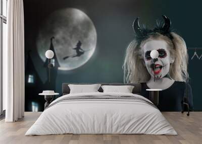 the girl wearing with horns. halloween make up. little girl scared on the background of the night Wall mural