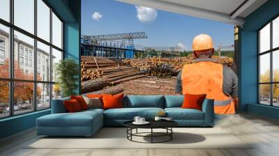 View of the backs of workers engaged in processing, loading and transporting wood. Wall mural