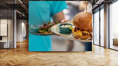 Waiter serving a delicious burger and sauce Wall mural