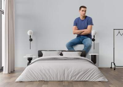 young man sitting on white cube. isolated Wall mural