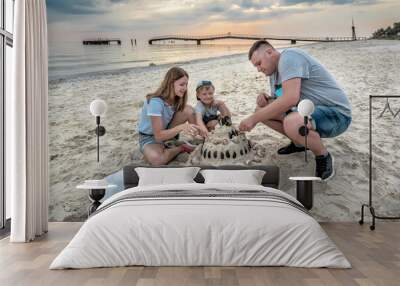 happy family builds a sand castle on the beach Wall mural