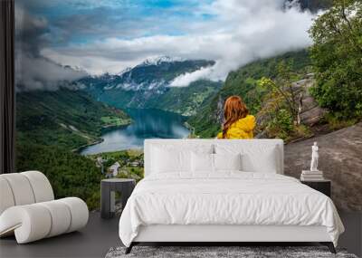 Woman in yellow sitting over Geiranger fjord Wall mural