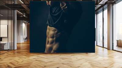 Undressing young man Wall mural