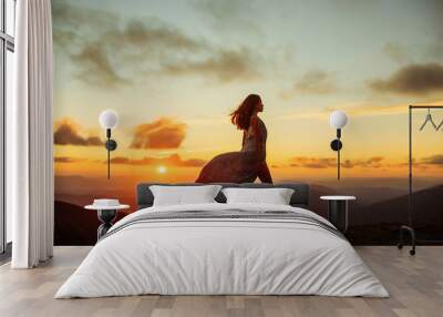 woman at sunset or sunrise in mountains Wall mural