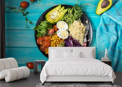 Healthy vegan lunch bowl. Vegan buddha bowl. Vegetables and nuts in buddha bowl on blue wood background. Top Wall mural