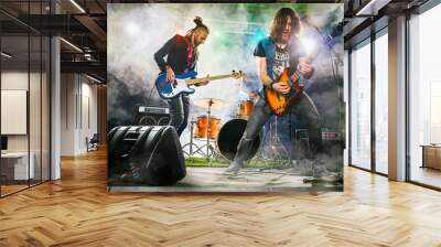 Rock band performs on stage. Guitarist, bass guitar and drums. The guitarist plays solo. Wall mural