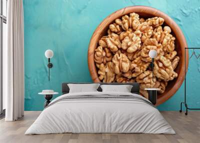 Close up of walnut halves in a wooden bowl on a colored background Promoting healthy eating and super foods Wall mural