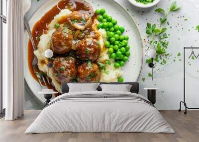 English meatballs with mashed potatoes peas and thick onion gravy on white plate classic British meal Wall mural