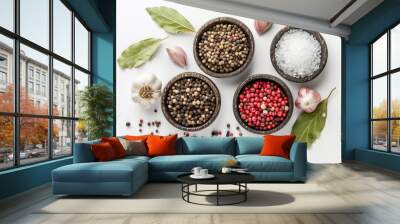 Spices on white background viewed from above including garlic salt pepper and bay leaf Wall mural