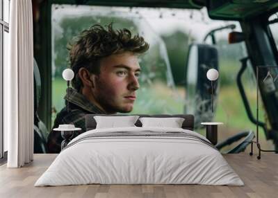 Young farmer driving tractor on farm with green fingers Wall mural