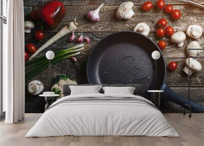 Food background on dark wooden table. Ingredients for cooking food with black pan. Top view, copy space. Wall mural