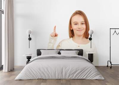 Guy pointing up at empty space. Boy gesturing new idea. Emotional portrait of happy teen boy over white background with copy space. Wall mural