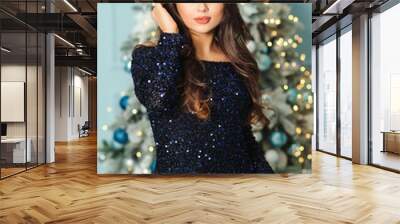 Lovely woman in evening dress over christmas tree background. Christmas holidays, celebration and sales Wall mural