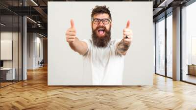 Lucky bearded hipster man over white background. Bearded man wearing glasses. Happy winner. Handsome bearded guy gesturing winner and keeping mouth open. Emotion and gesturing concept. Wall mural