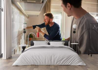 Gay couple cleaning modern kitchen at home Wall mural