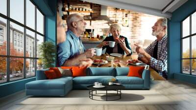 group of senior friends having breakfast together in the kitchen Wall mural