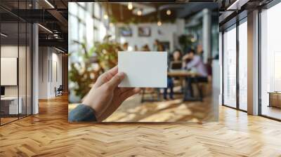 Hand holding blank white card in startup office Wall mural