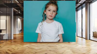 Portrait of a cute female child against green background Wall mural