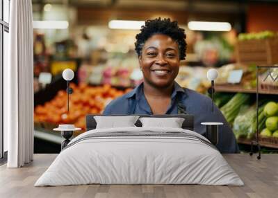 Portrait of a smiling African American female grocery store employee standing in produce aisle Wall mural