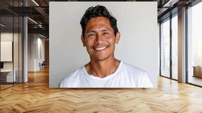 Portrait of a young adult handsome man in white t shirt smiling while standing against white background Wall mural