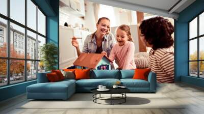 Young family painting a doll house at home Wall mural