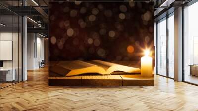 a bible on the table in the light of a candle Wall mural