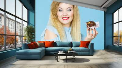 Attractive woman holds cake in hand Wall mural