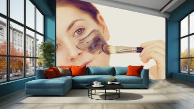 Woman apply black carbo mask to face Wall mural