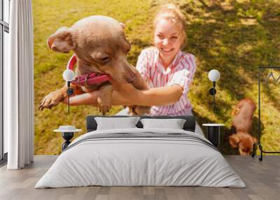 Woman playing pinscher ratter dog outside Wall mural