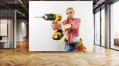 Woman using drill on wall Wall mural