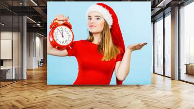 Woman wearing Santa Claus costume holding clock Wall mural