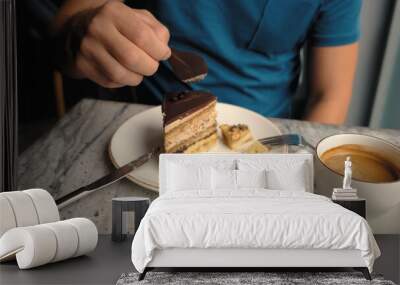 a man in a cafe eats chocolate decor from a cake Wall mural