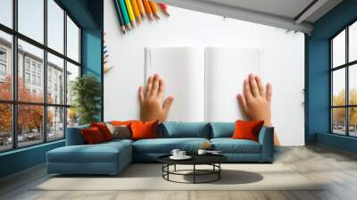 Close-Up of Children's Hands with Coloring Book and Pencils Around. Suitable for children's education concept. Wall mural