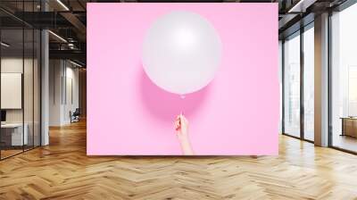 Party banner, celebration birthday or anniversary concept. One round balloon and hand holding it on pink background, 3d illustration Wall mural