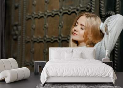 Closeup portrait of sensual girl with natural makeup posing near metal wrought door. Space for text Wall mural