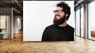 Attractive bearded man with stylish hair and beard smiling and looking away Wall mural