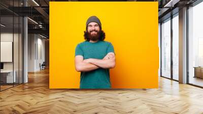 Cheerful smiling bearded hipster man looking confident at the camera Wall mural