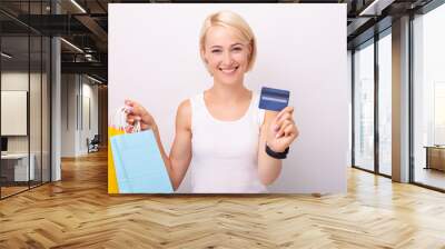 Close up portrait of amazed beautiful woman holding shopping bags and credit card Wall mural