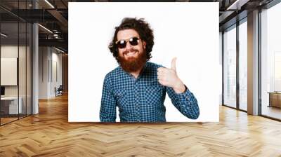 Life style and people concept: Happy handsome man with beard in sunglasses showing thumbs up. Smiling happy hipster man with beard over white background. Man with curly hair and beard. Smile. Wall mural