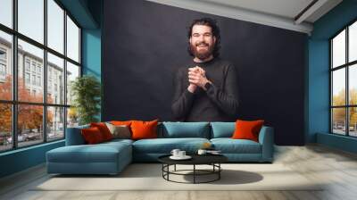 Portrait of charming young handsome bearded man looking at the camera. Wall mural