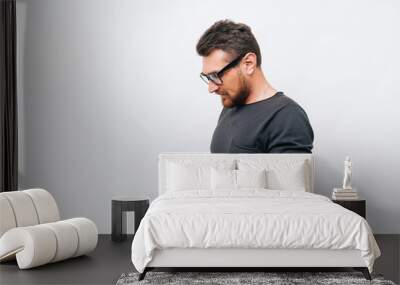 Portrait of young handsome man using smartphone over white background Wall mural