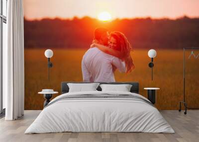 Summer sunset lights, a couple having fun in field Wall mural