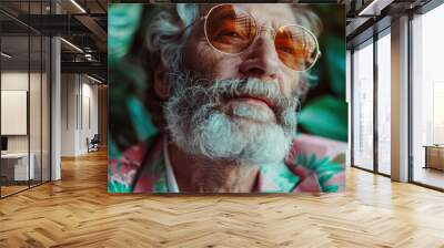 A man with a white beard and sunglasses, in a vintage floral suit, reflecting a thoughtful and pensive mood, highlighting a blend of classic and modern elements amid greenery. Wall mural