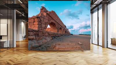 Aqueduct in ancient city Caesarea at sunset. Creative color Wall mural