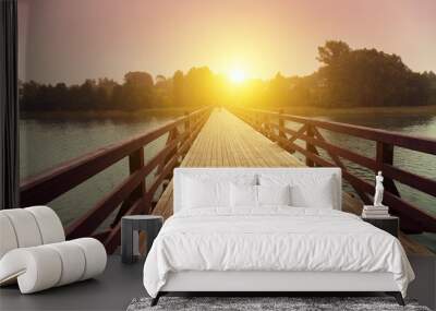 Wooden bridge over lake in early misty morning Wall mural