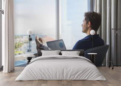 young businessman in casual attire working on laptop at home office Wall mural