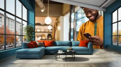 African man in traditional attire using mobile phone isolated in store Wall mural