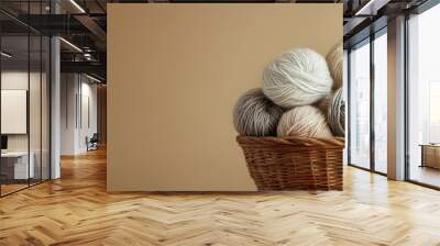 Beige woolen yarn skeins for knitting tumbled out of the handcrafted brown basket Materials for knitting crafts and hobbies. with copy space image. Place for adding text or design Wall mural